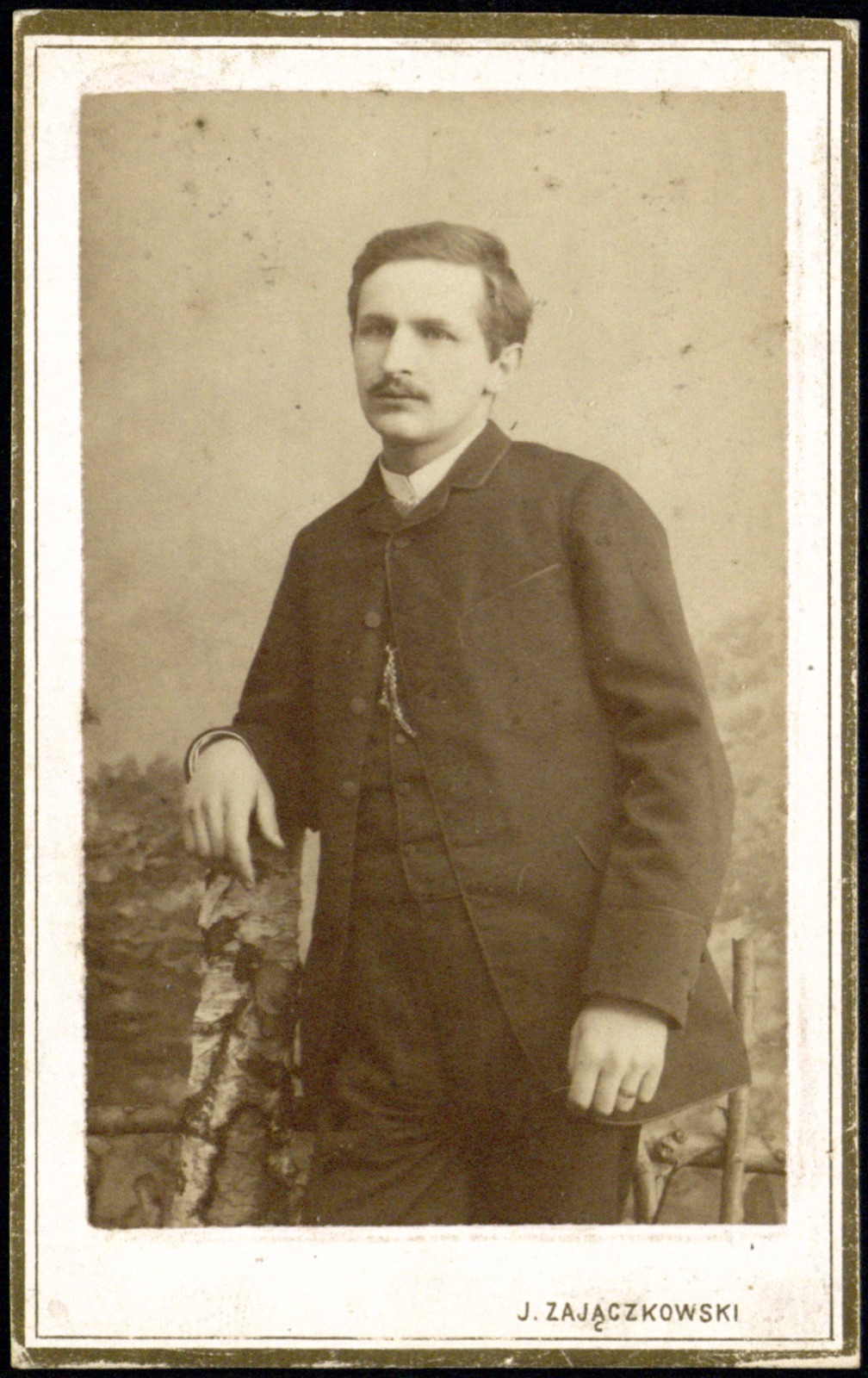 portret młodego mężczyzny przy pieńku brzozowym