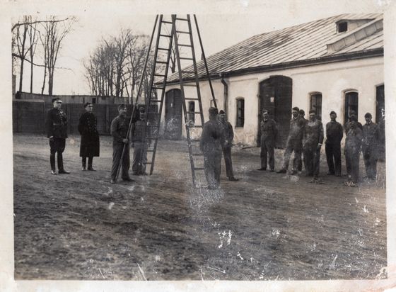 Umundurowana grupa przed długim budynkiem
